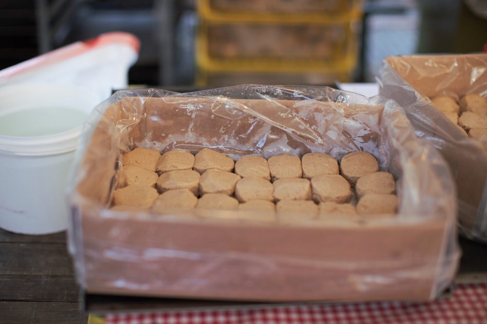 778159 - Insu Suministros | Hablemos de Marketing Box of small round cookies lined with plastic, on a bakery worktable